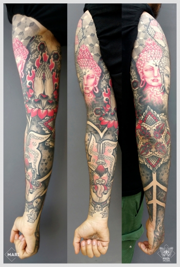 Fotografia di un braccio e mano tatuati in stile ornamentale e dotwork, raffiguranti, tre Buddha, mani in preghiera, svastica, fiore di loto e demoni, con sfondi a texture e pattern geometrici. Il tatuaggio è stato eseguito da Marianna Bevilacqua